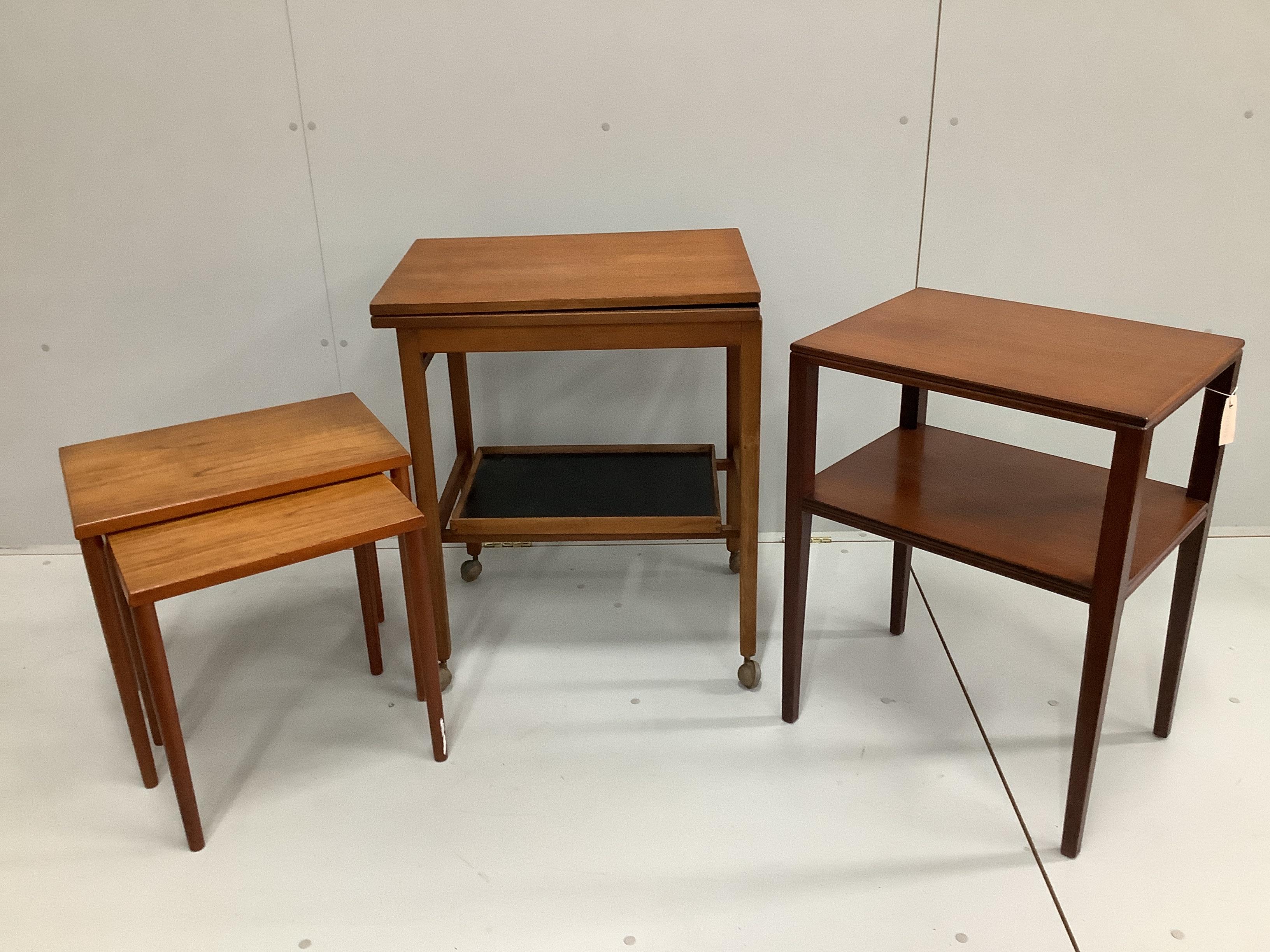 A mid century teak two tier occasional table, width 50cm, depth 38cm, height 68cm together with a nest of two rectangular teak tea tables and a hinge top tea trolley
